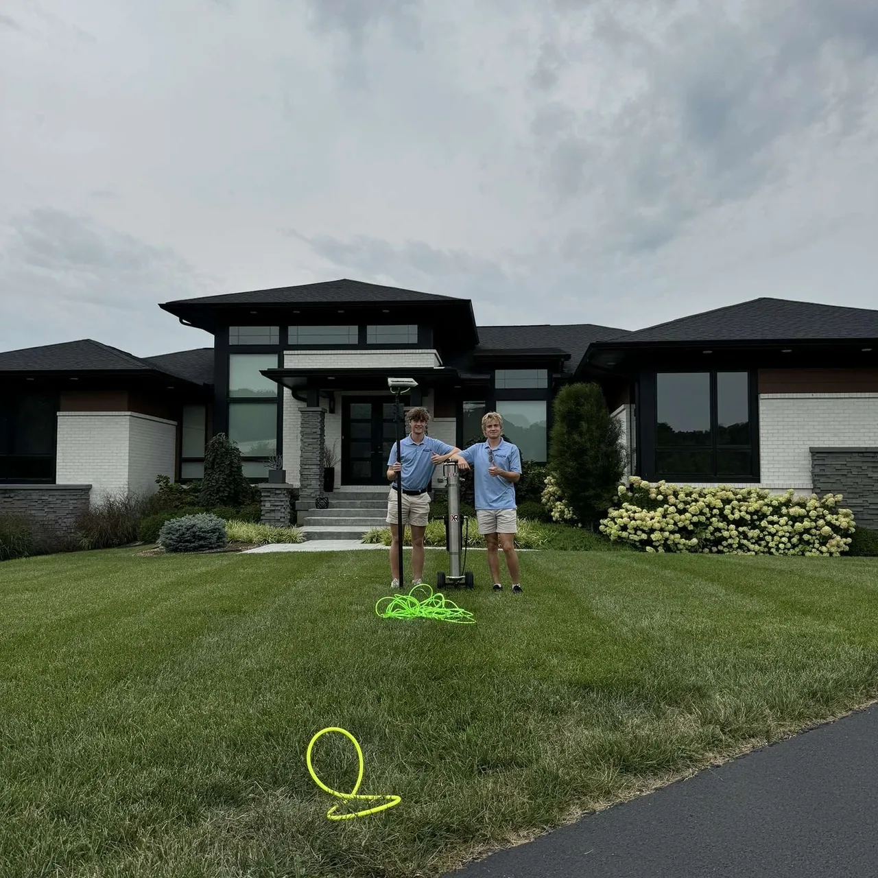 Two people standing in front of house.