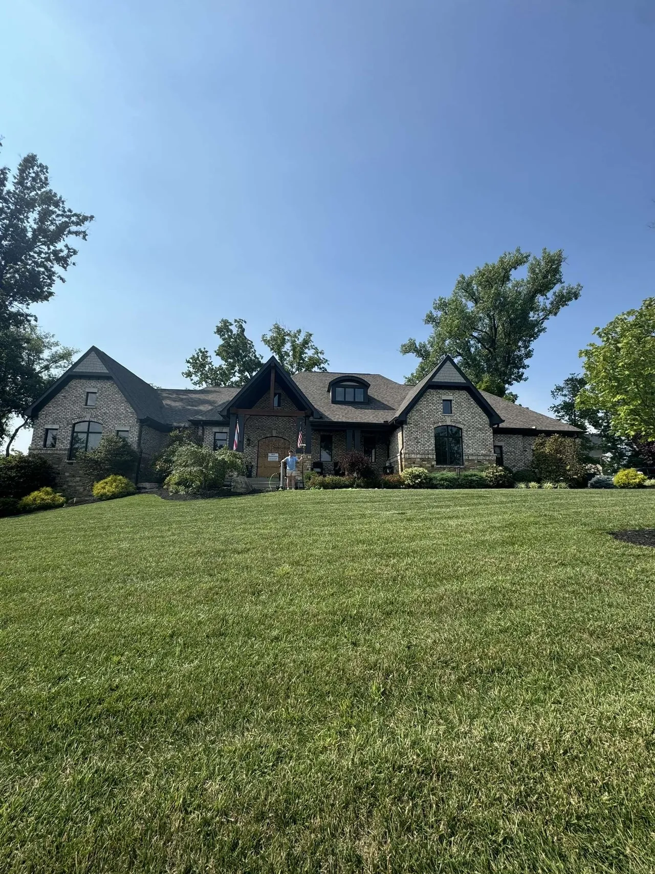 Large stone house with green lawn.