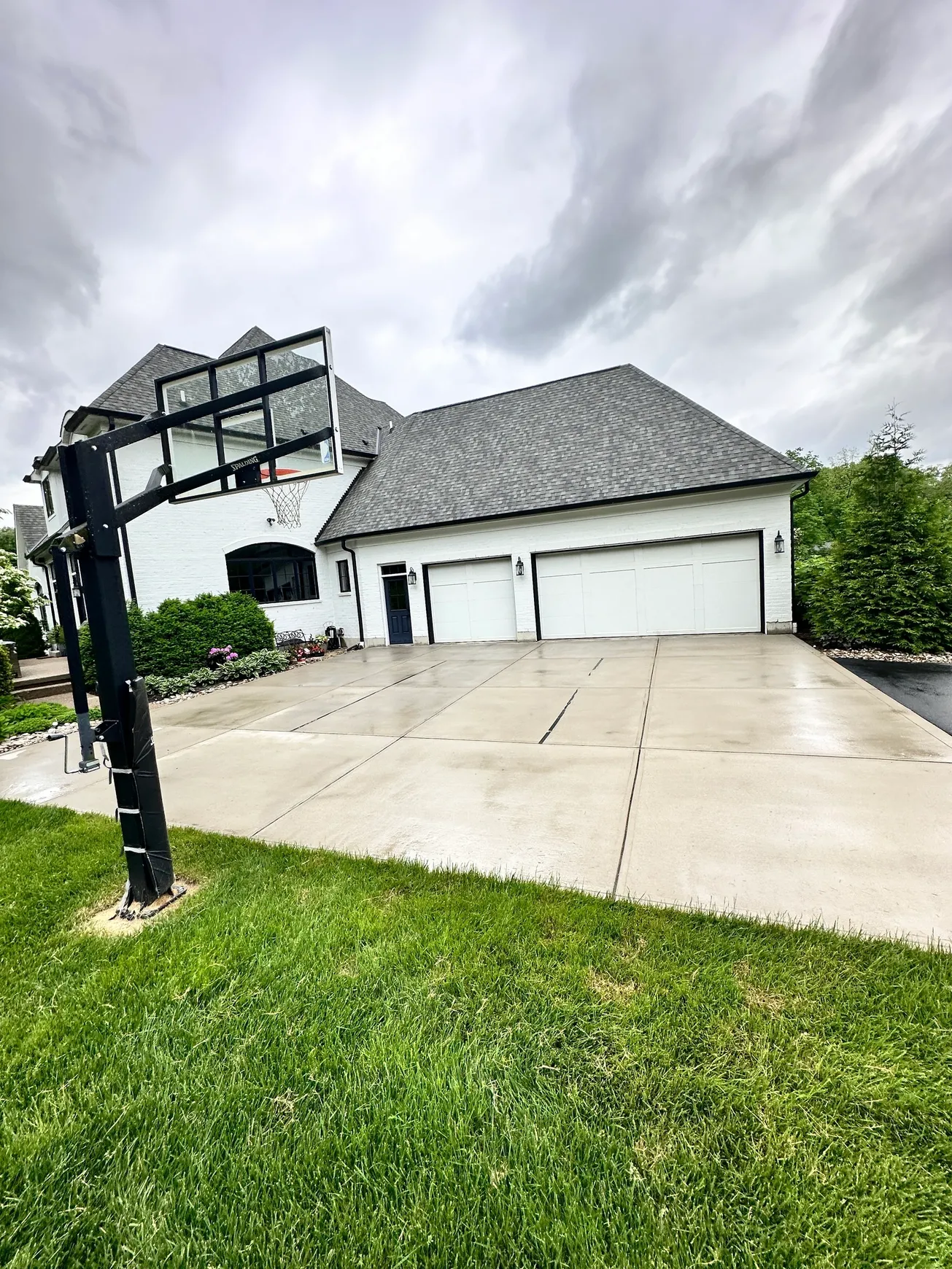 Modern house with driveway and basketball hoop.