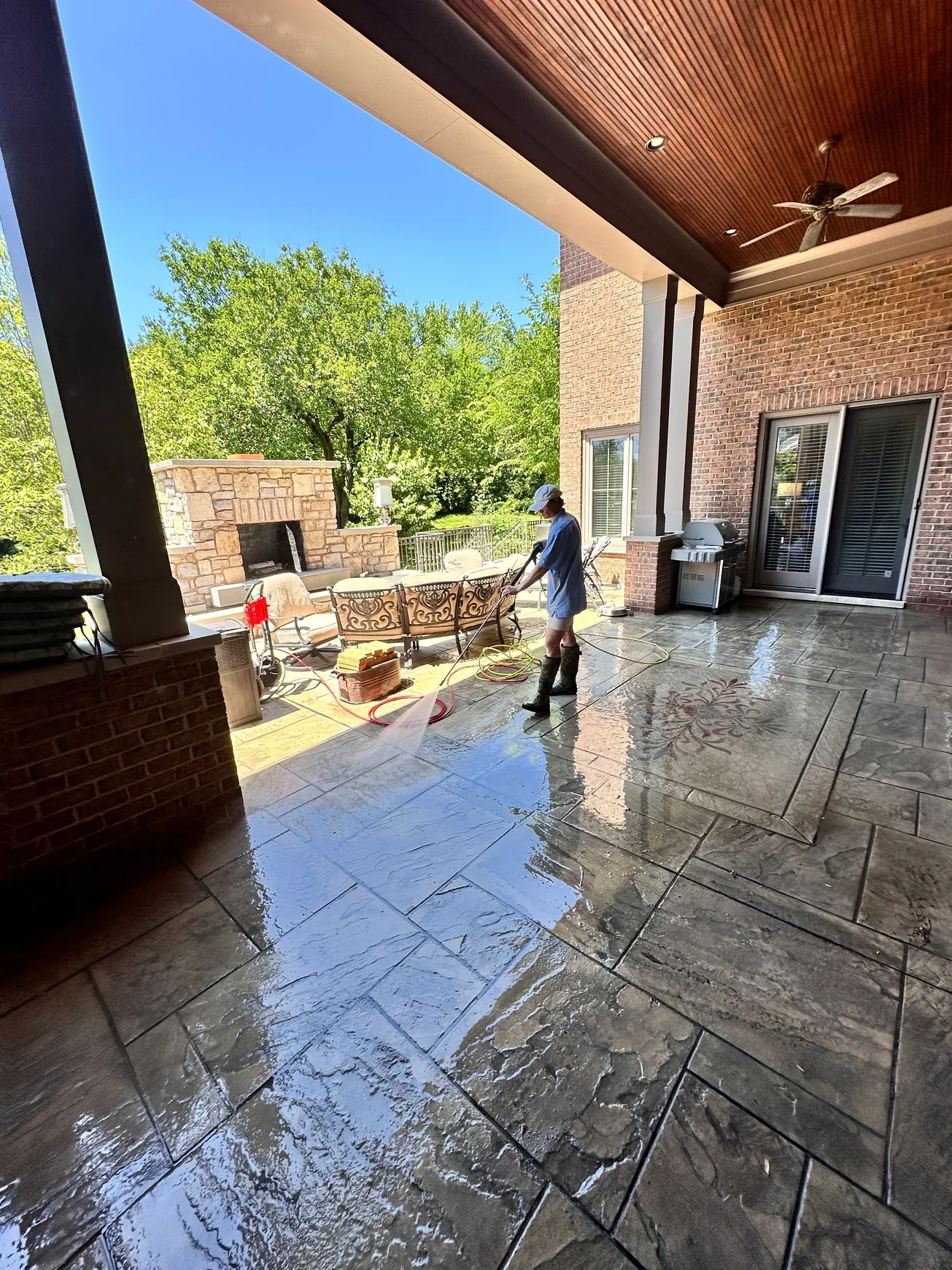 rs=w_2320,h_1740 Person cleaning large patio with hose.
