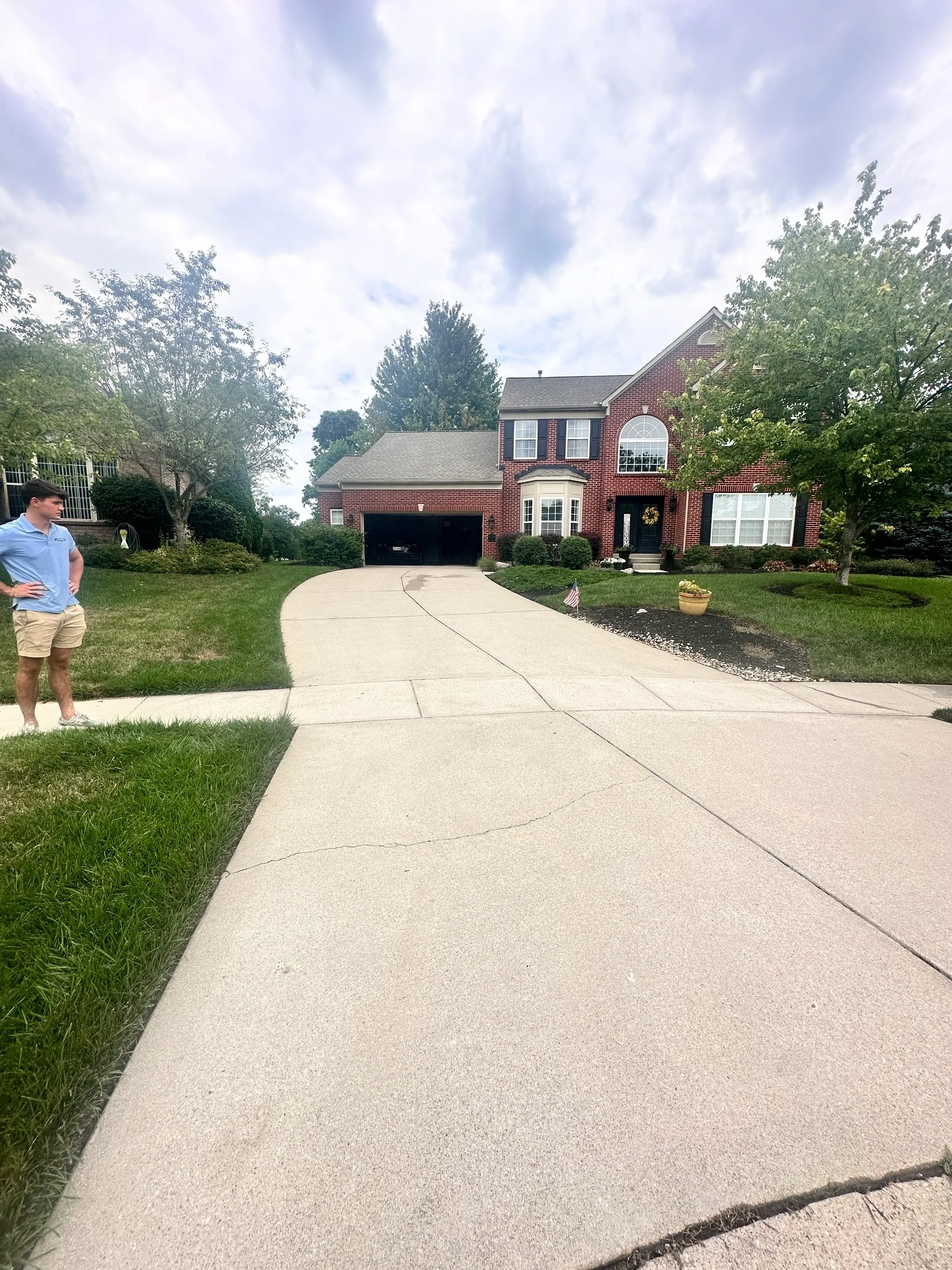 Two-story brick house with driveway and trees.