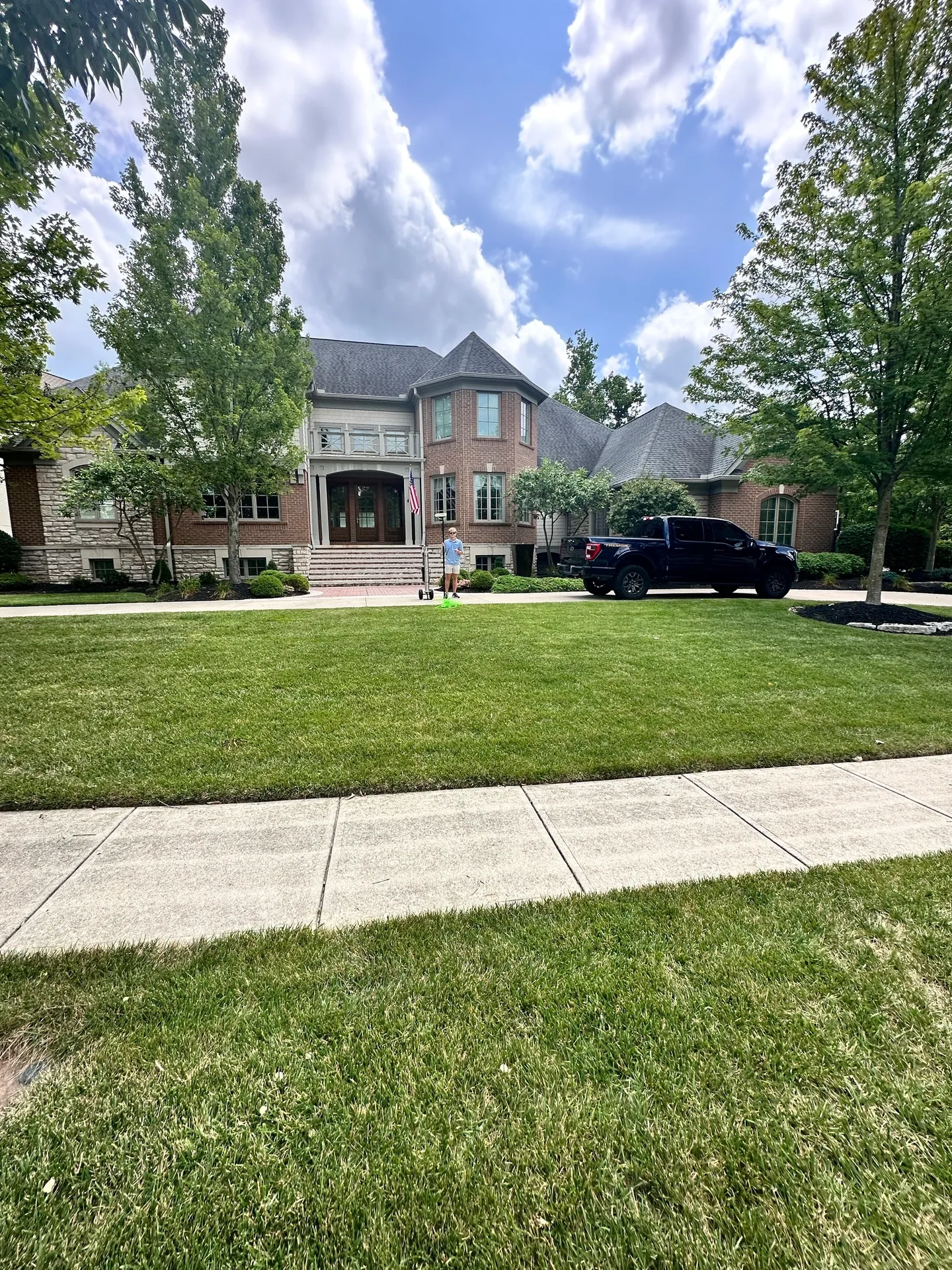 Large house with a spacious green lawn.