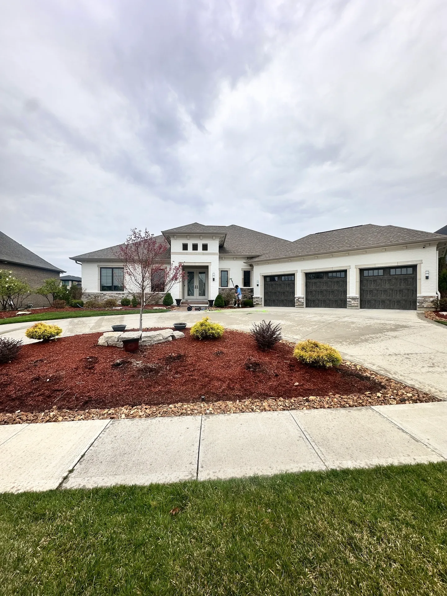 Modern house with three-car garage and landscaping.