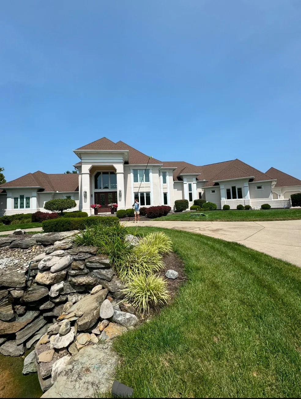 Luxurious mansion with well-maintained lawn and driveway.