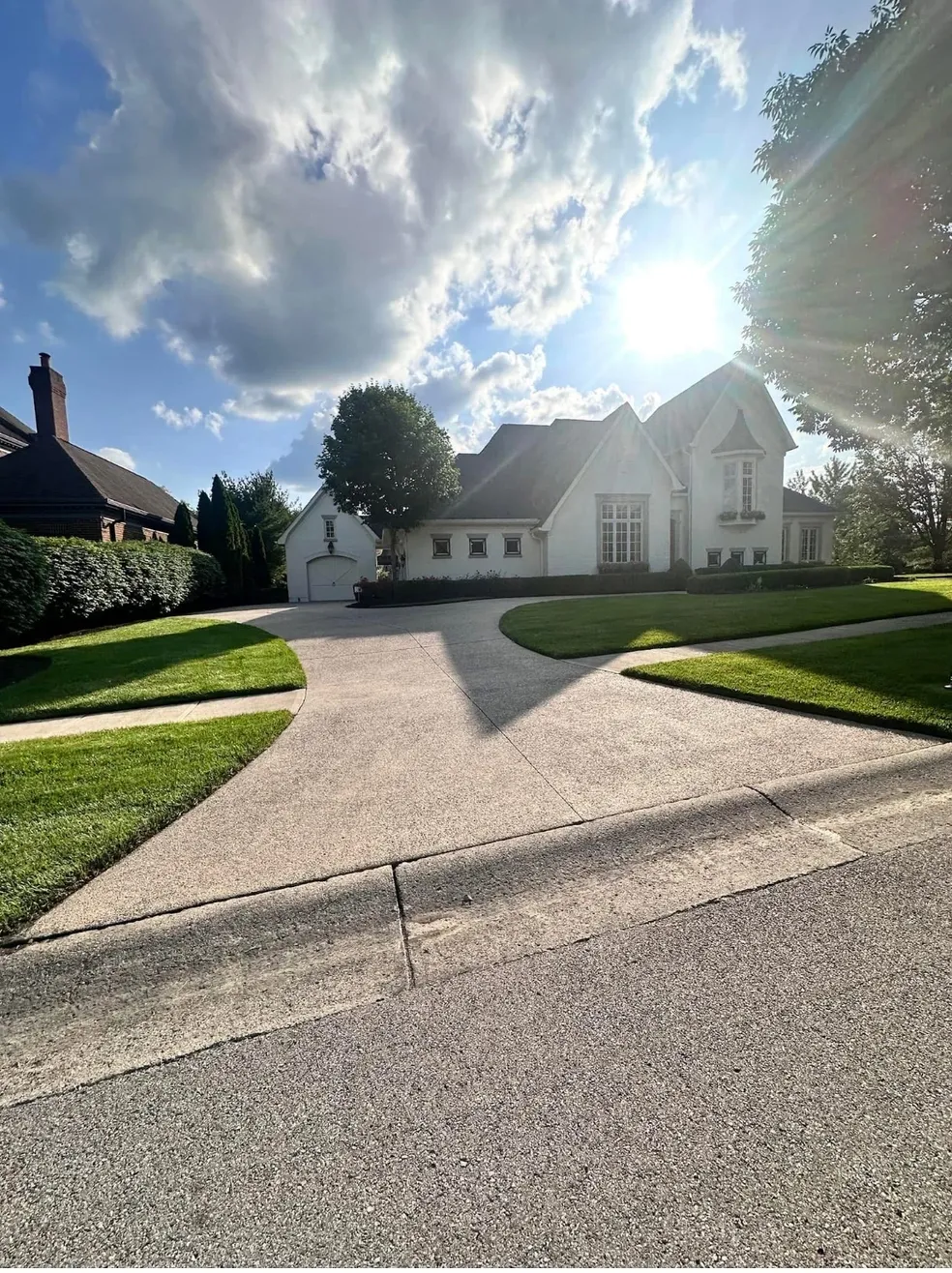 Sunny suburban house with green lawn.