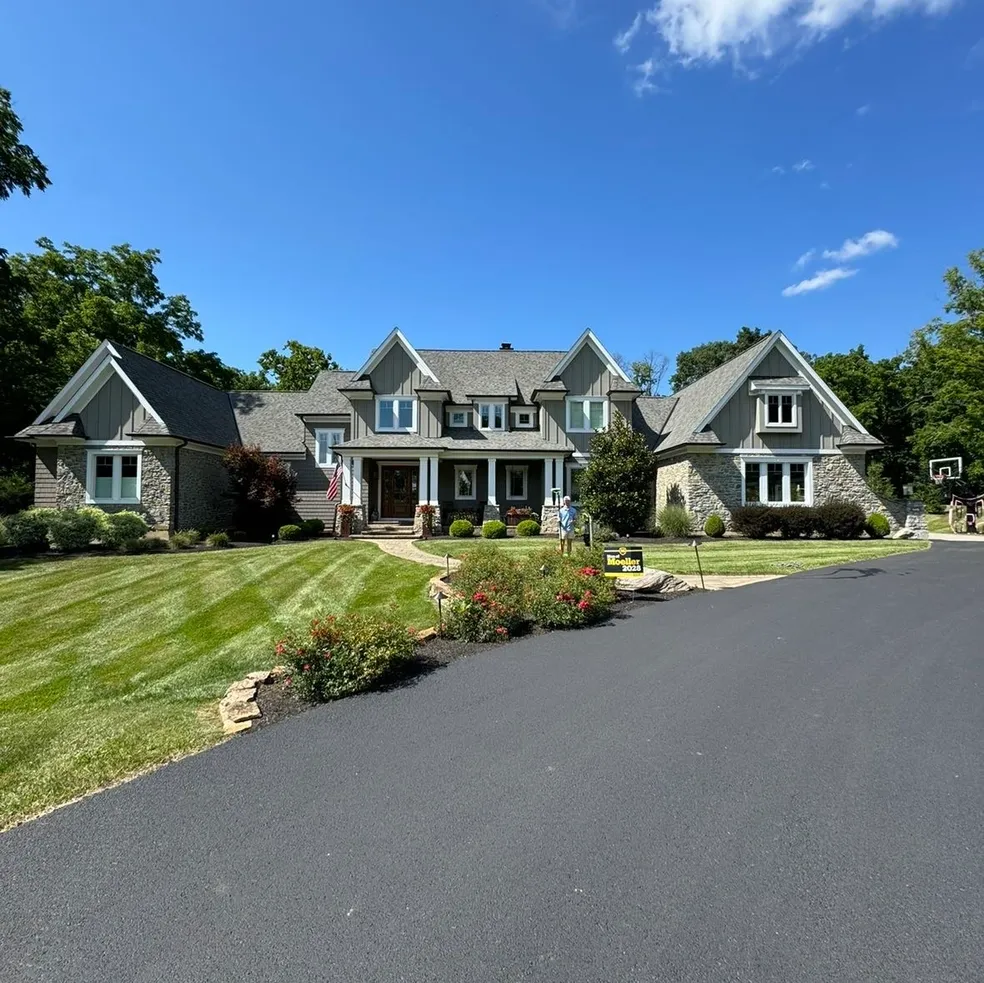 Large stone house with manicured lawn.