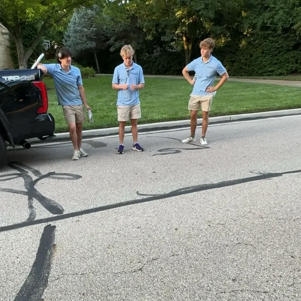 rs=w_984,h_984 Three people standing by a black truck.