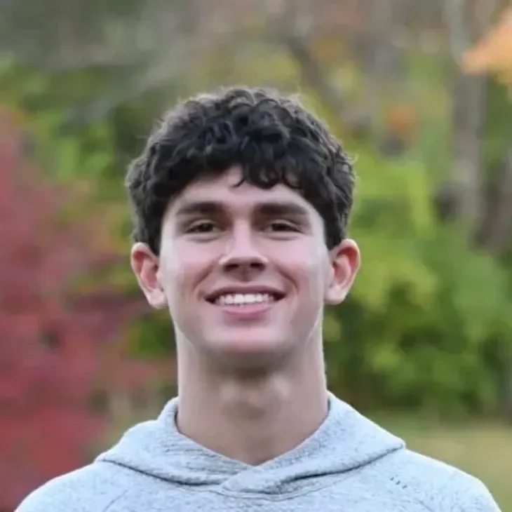 eli Smiling person outdoors with colorful background.