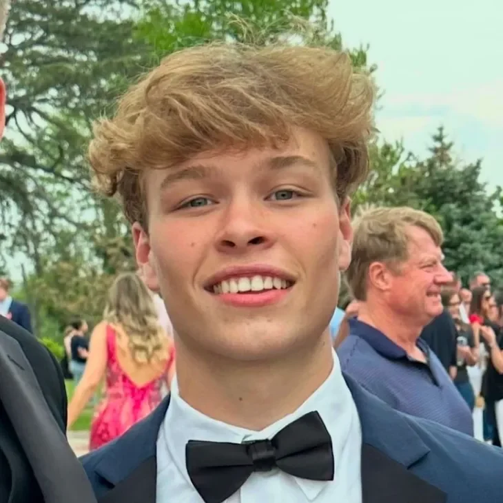 matthew Young man smiling in formal attire outdoors.
