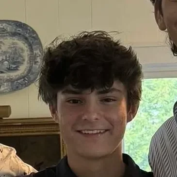 nick Smiling person indoors with decorative plate.